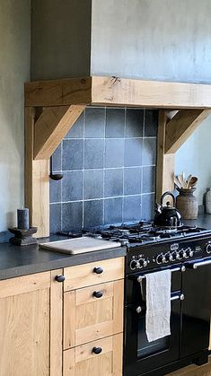 a black stove top oven sitting inside of a kitchen next to wooden cabinets and counter tops