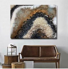 an abstract painting on the wall above a couch in a room with two chairs and a coffee table