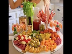 a woman standing in front of a platter filled with different types of appetizers