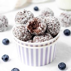 a bowl filled with blueberries and chocolate covered donuts