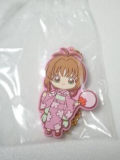 a plastic keychain with a cartoon girl holding a heart shaped object in it's hand