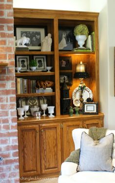 a living room filled with furniture next to a brick wall