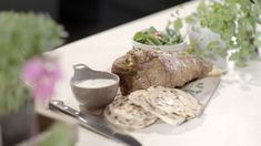 some food is laying out on a table with utensils and flowers in the background