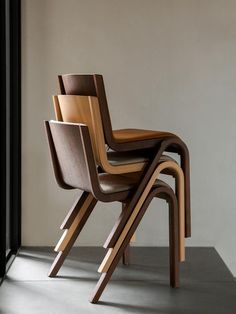 a stack of wooden chairs sitting next to each other on top of a cement floor