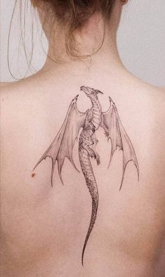 a woman's back with a dragon tattoo on her left shoulder and the words iron ink above it