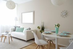 a living room filled with furniture and a white table in front of a large window