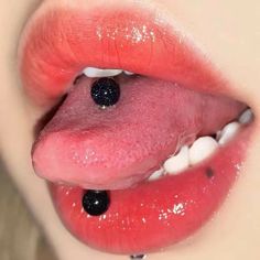 a woman's tongue with blackberries sticking out of the top of her lip