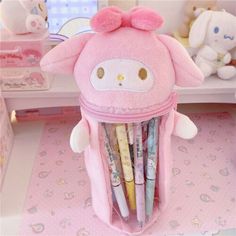 a pink hello kitty pencil holder filled with pens