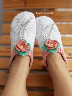 a person wearing crocheted slippers with flowers on them sitting on a bench