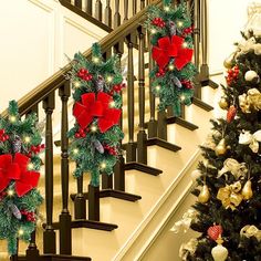 three christmas wreaths on the banister next to a staircase decorated with pine cones and red bows