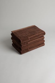 six brown towels stacked on top of each other