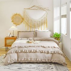 a bedroom with a large bed covered in beige linens and tasseled pillows