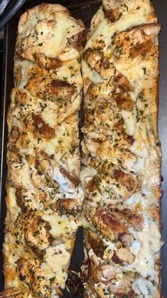 two pieces of pizza sitting on top of a metal pan covered in cheese and herbs