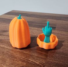 an orange and blue plastic pumpkin sitting on top of a wooden table