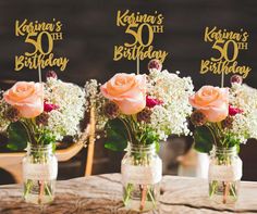 three mason jars filled with flowers sitting on top of a table next to each other