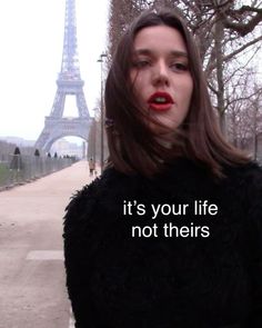 a woman standing in front of the eiffel tower