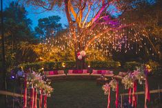 an outdoor seating area decorated with lights and flowers