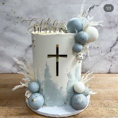 a cake decorated with blue and white decorations on top of a wooden table next to a marble wall