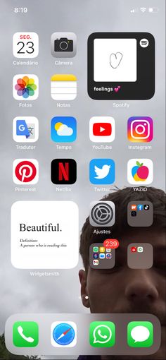 an iphone screen with several different icons on the phone and in front of it is a man's face