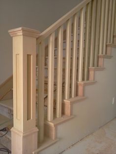 an unfinished stair case in a house with no carpet on the floor and only one handrail