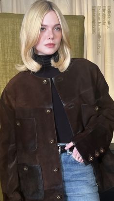 a blonde woman wearing a brown jacket and tie