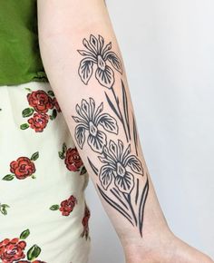 a woman's arm with flowers on it and a flower tattoo on the left side of her arm