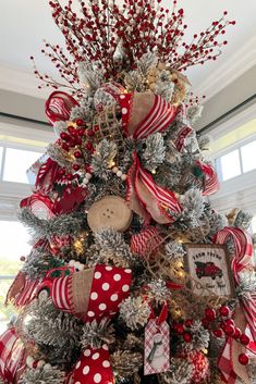 a decorated christmas tree with red and white ribbons