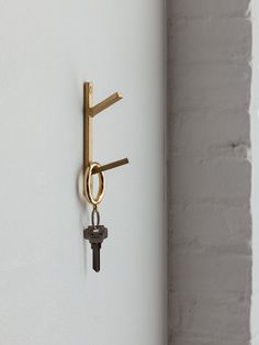 a key is hanging from a hook on the wall