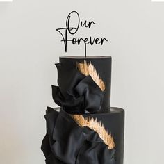 a black and gold wedding cake with the words our forever on top