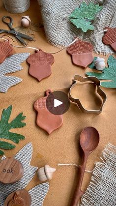 wooden spoons and cookie cutters sitting on top of a table covered in leaves