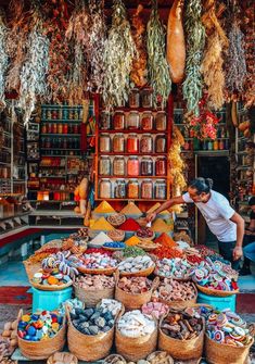 a man standing in front of a store filled with lots of food