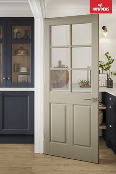 an open door leading to a kitchen with blue cabinets