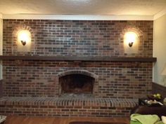 a living room with a brick fireplace and two lights