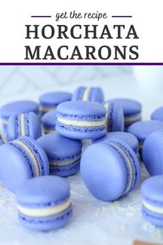 blue macarons with white frosting and purple icing are on the table