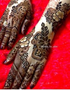 the hands and feet of a woman with henna tattoos