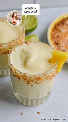 two glasses filled with dessert sitting on top of a counter next to lime wedges