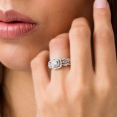 a close up of a woman's hand with a diamond ring on her finger