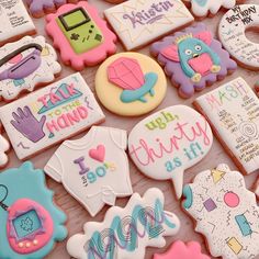 decorated cookies are displayed on a table for someone's special day to be served