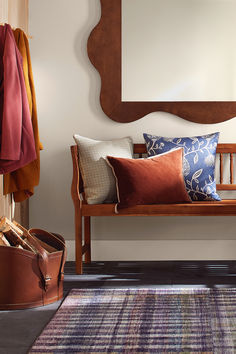 a wooden bench sitting in front of a mirror on top of a wall next to luggage