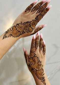 two hands with henna tattoos on them