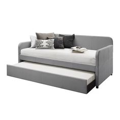 a gray daybed with two pillows on it and a pull out sofa bed underneath