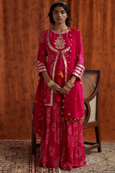 Featuring a hot pink kurta in chiffon and georgette base with gota and bandhani embroidery. It is paired with matching bandhani sharara pants and a dupatta having tassels.  Disclaimer: As bandhani and leheriya are hand made, a little difference in pattern and colour is possible.  FIT: Fitted at bust and waist. COMPOSITION: Chiffon, Georgette. CARE: Dry clean only. Bandhani Lehenga, डिजाइनर कपड़े, Best Blouse Designs, Beautiful Pakistani Dresses