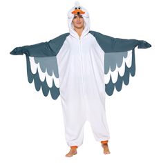 a man in a bird costume is standing with his arms spread out and eyes closed