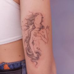 a woman's arm with a tattoo on it that has a drawing of a mermaid