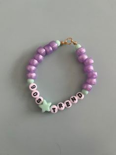 a purple and green beaded bracelet with words on it