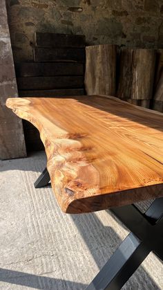 a wooden table sitting on top of a cement floor next to some wood planks