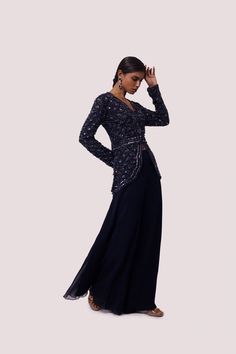 Exquisite navy blue georgette embellished co-ord set is perfect for parties and wedding occasions. It is crafted with cutdana and tikki work. The set is made of georgette fabric. Shop online from Pure Elegance. Disclaimer: The actual product may vary slightly from the image. These are custom orders, hence expect slight variation in color and placement of the motif or buta. ESTIMATED DELIVERYBecause this is a custom order, it would take about 4 weeks from the date of purchase. RETURN POLICYThis product is a custom order and cannot be returned or exchanged. Embellished Georgette Choli For Evening, Formal Embellished Georgette Set, Glamorous Evening Choli In Georgette, Evening Embellished Georgette Choli, Hand Embellished Sharara For Evening Party Wear, Glamorous Evening Georgette Choli, Festive Hand Embellished Palazzo Set For Party, Diwali Party Embellished Palazzo Set, Hand Embellished Georgette Party Sets