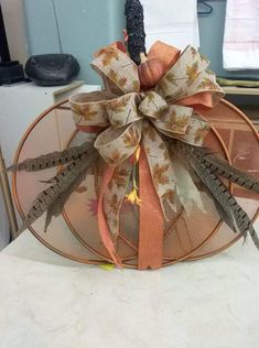 a metal mesh pumpkin with a bow on it's top sitting on a counter