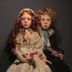 two dolls are sitting next to each other