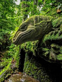 an animal statue made out of moss in the jungle